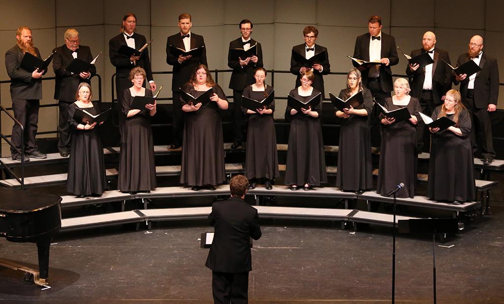 Choral concert singers with our director Jeremy in front conducting